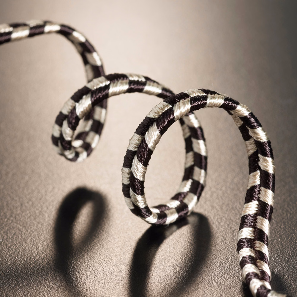 Ivory and near-black striped soutache cord looping with raised ribbed texture and shadows