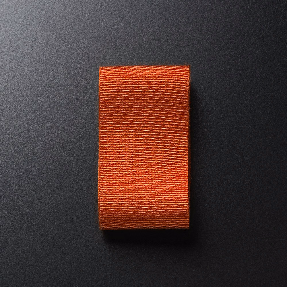 Burnt-orange textile swatch with fine, densely spaced horizontal ribs and subtle red-brown depth