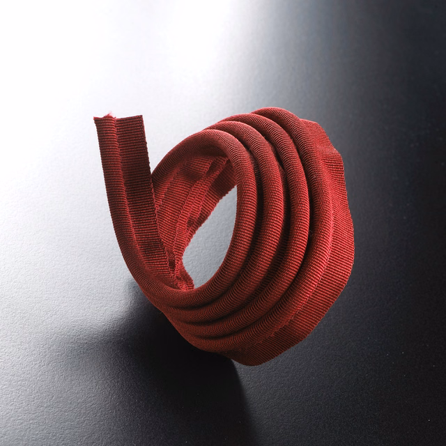 Deep Bordeaux red ribbed lipcord curled into a rounded roll
