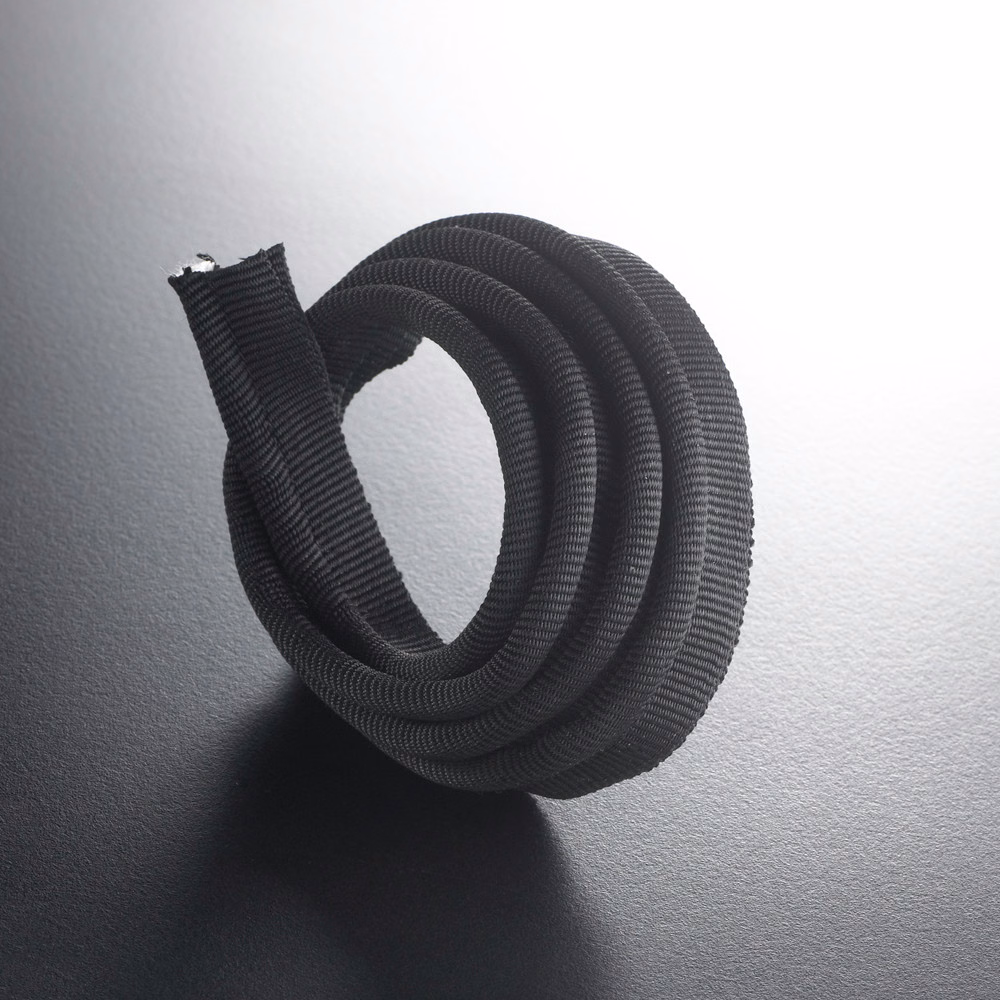 Near-black ribbed lipcord coiled into a loop, showing its rounded textured profile