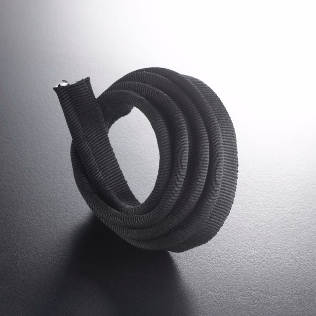 Near-black ribbed lipcord coiled into a loop, showing its rounded textured profile