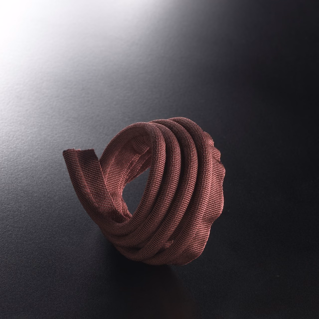 Deep plum ribbed lipcord looped into a sculptural rounded coil