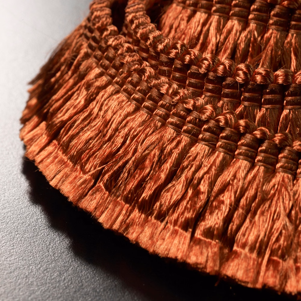 Burnished terracotta fringe with glossy strands and dark brown wrapped bands