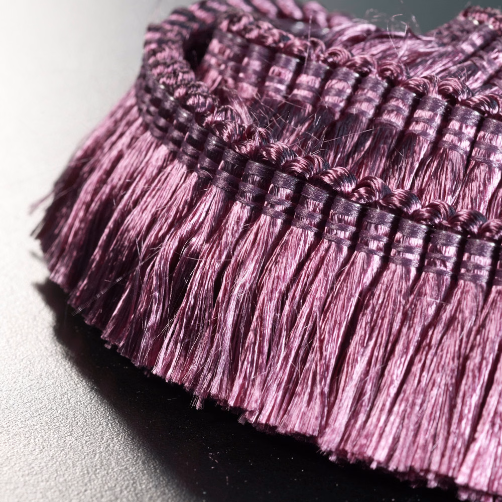 Close-up of dense plum-purple fringe with glossy violet highlights and dark woven bands