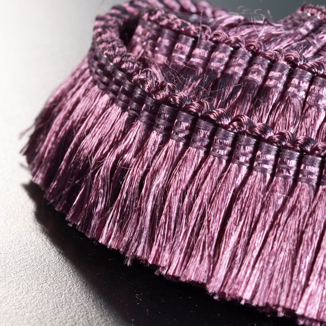 Close-up of dense plum-purple fringe with glossy violet highlights and dark woven bands