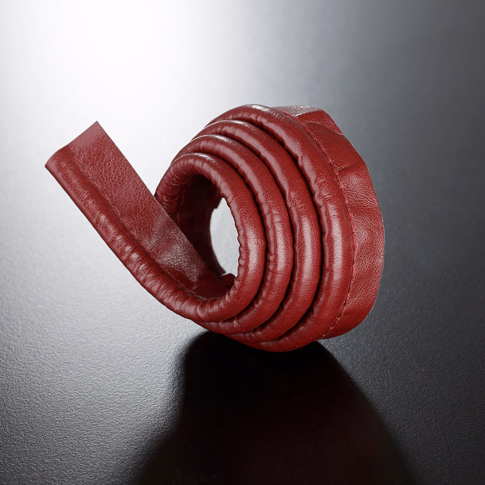 Deep Bordeaux-red pebbled lipcord coiled into a rounded spiral