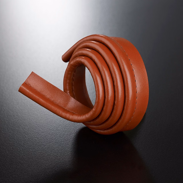 Warm russet-brown lipcord coiled into rounded loops on a black surface