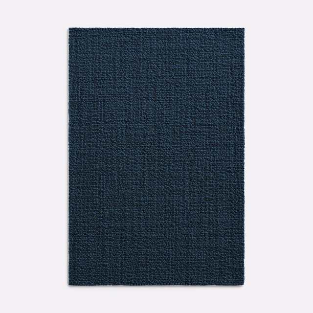 Close-up of dark indigo woven fabric with subtle tonal texture and low sheen