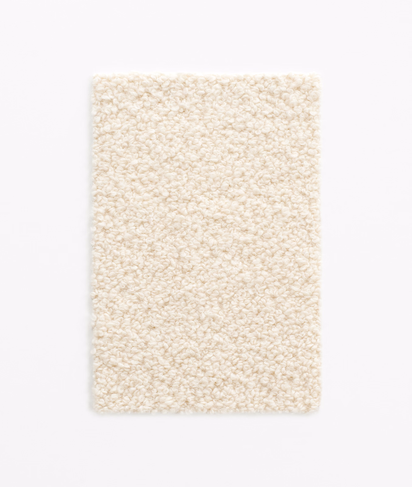 Warm ivory bouclé swatch showing dense, irregular loops and a softly nubby surface