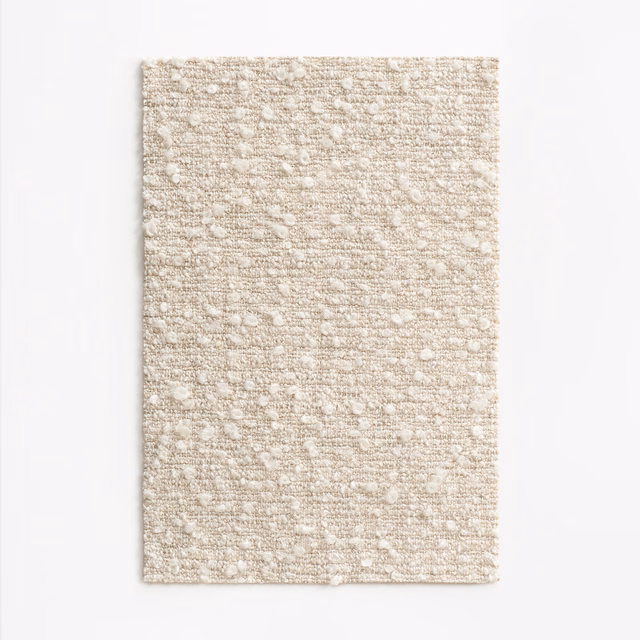Warm ivory-beige upholstery weave with horizontal slubs and scattered raised flecks
