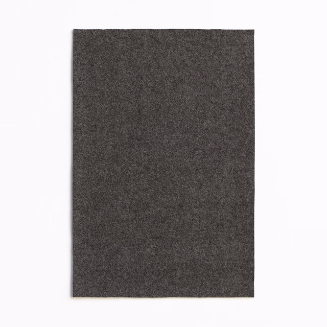 Deep charcoal grey textile swatch with a finely mottled, near-black surface