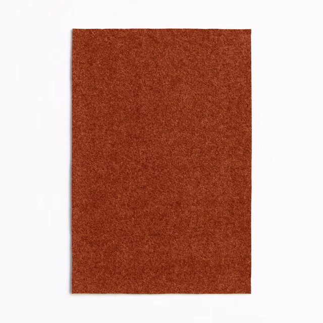 Rust paprika upholstery swatch showing a dense, softly mottled woven texture