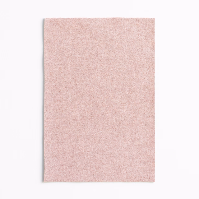 Pale dusty rose upholstery fabric with a fine, softly mottled surface