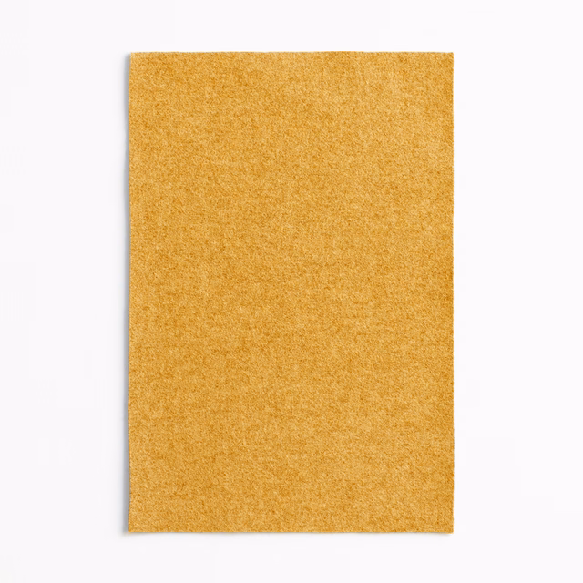 Dense mottled mustard-yellow upholstery fabric with a softly textured plain surface