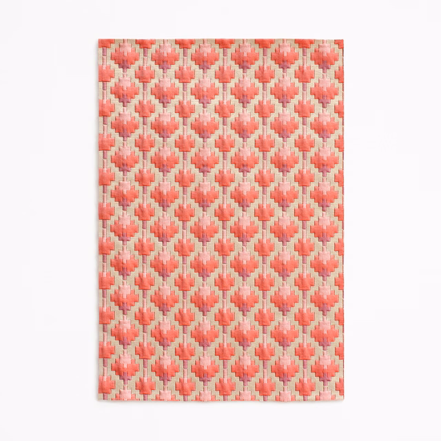 Warm coral-red woven fabric with blush diamonds and pale cream vertical accents