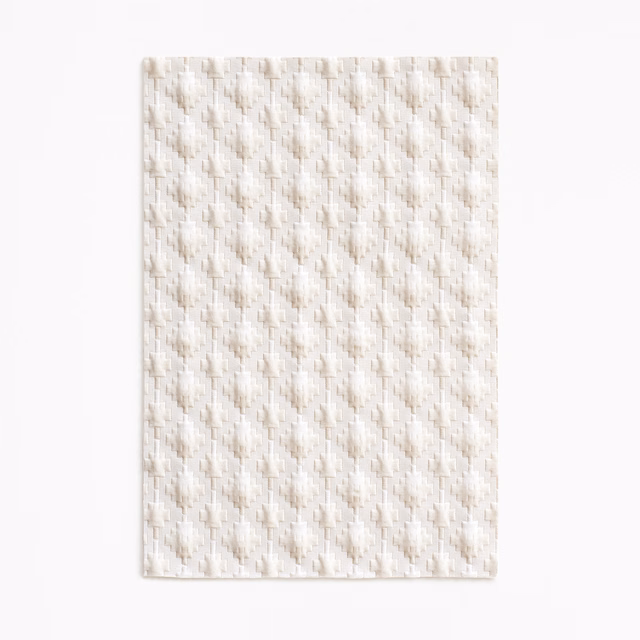 Warm ivory upholstery swatch with small raised geometric woven motifs in vertical rows