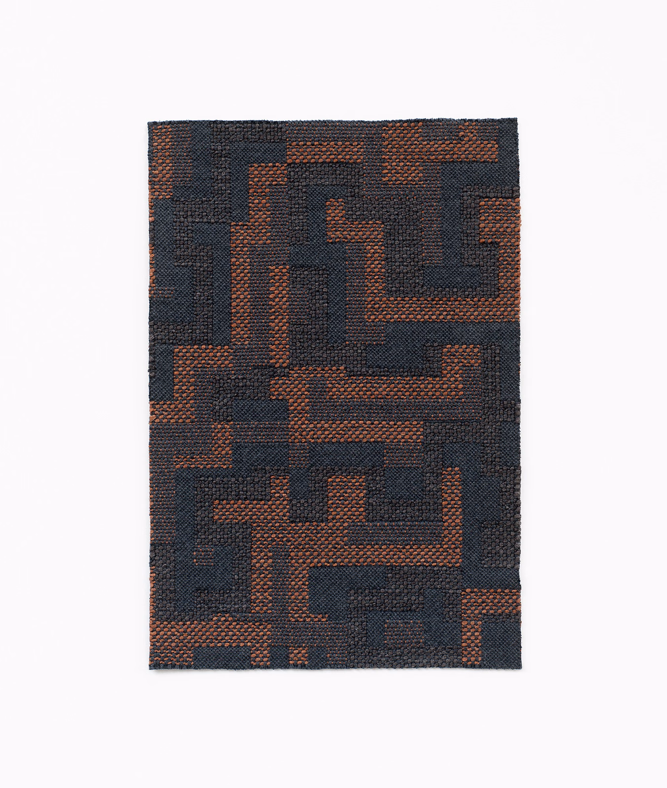 Dark charcoal woven swatch with russet maze-like geometric blocks