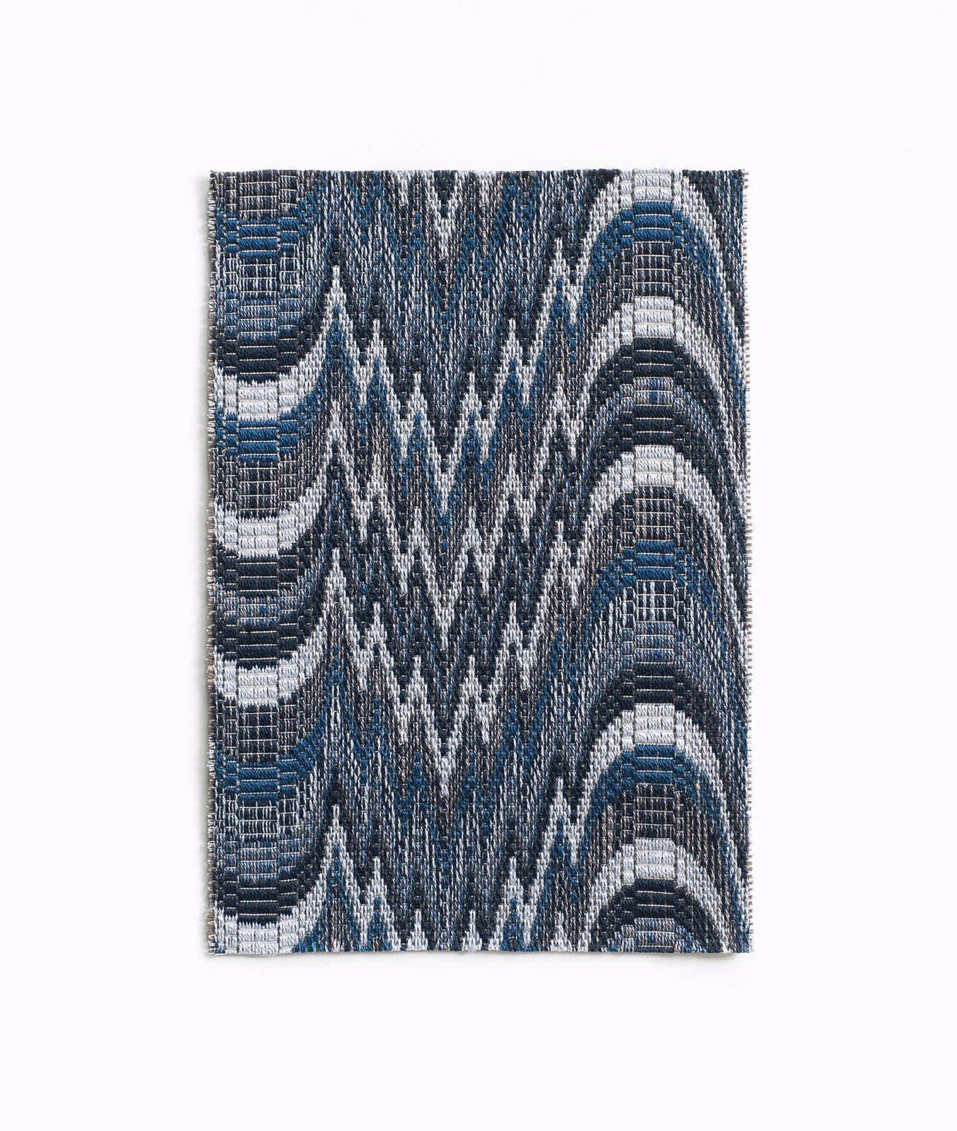 Cool indigo woven textile with white zigzags and curved blue-grey bands