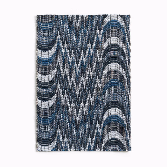 Cool indigo woven textile with white zigzags and curved blue-grey bands