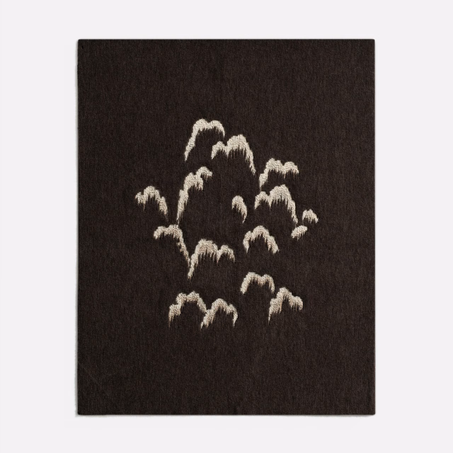 Dark espresso-brown fabric with clustered ivory brushstroke motifs and softly raised texture