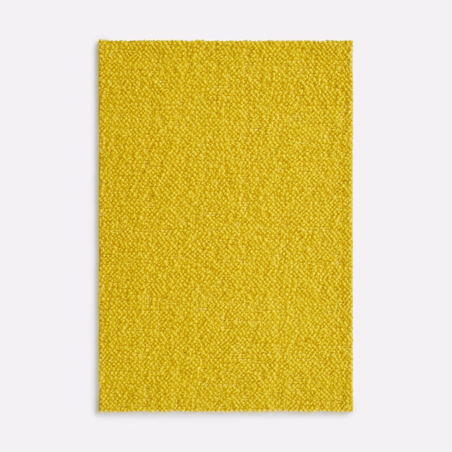 Close-up of bright sulphur-yellow nubby woven textile with a pebbled surface