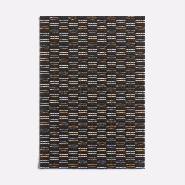 Charcoal black woven fabric with warm taupe flecks in vertical geometric columns