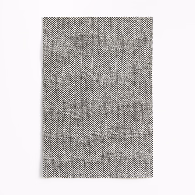 Dense warm-grey upholstery swatch with a tiny charcoal micro-check woven texture
