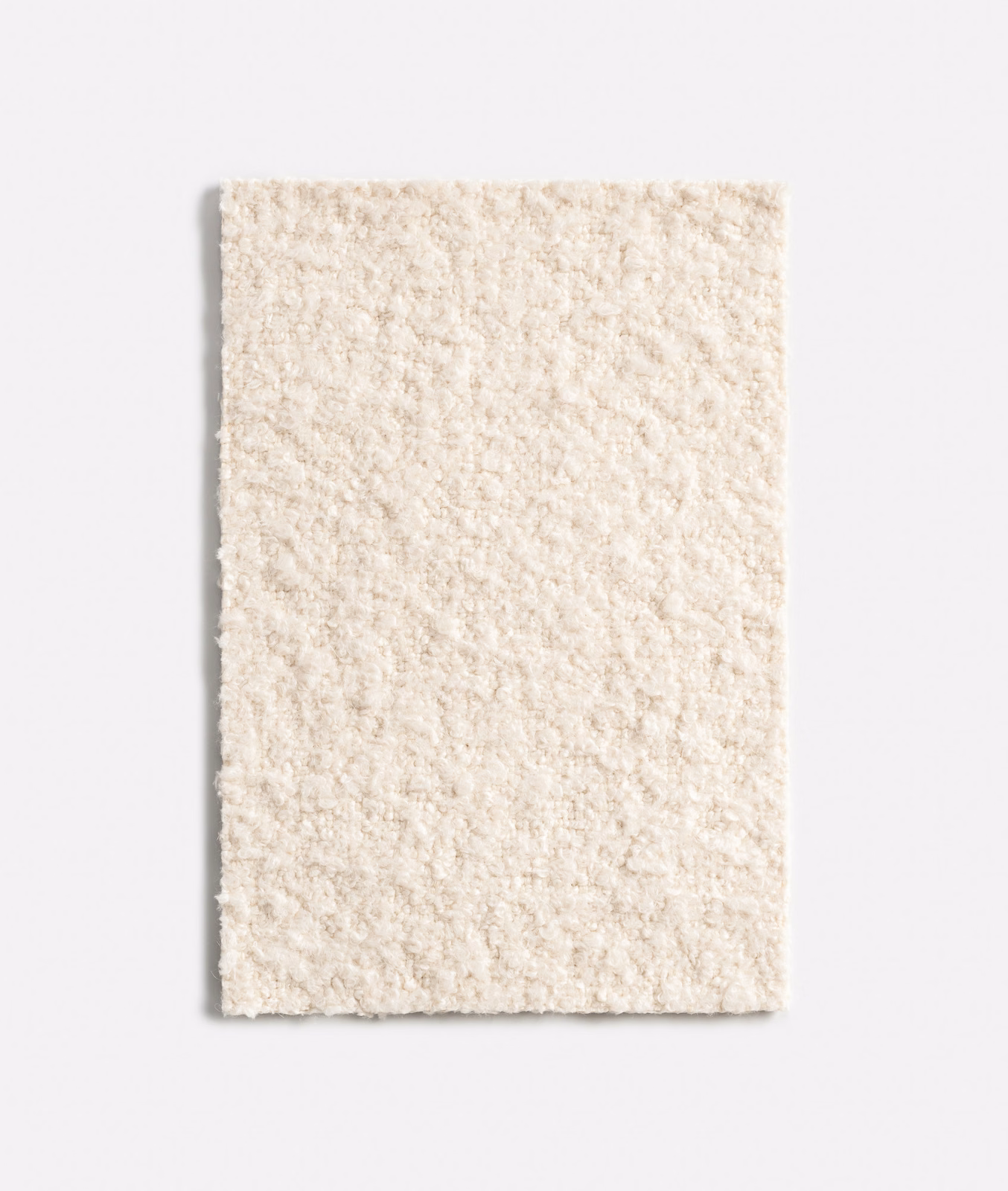 Warm ivory nubby textile with softly irregular, bouclé-like surface texture