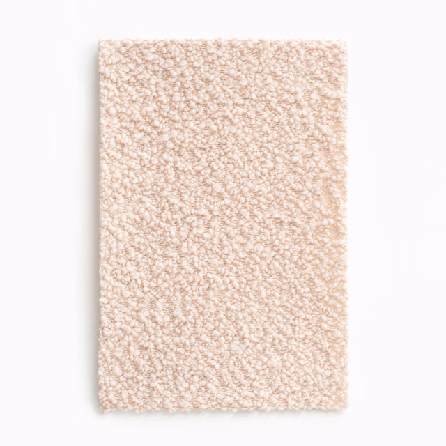 Pale blush-nude upholstery fabric with a dense, softly looped bouclé surface