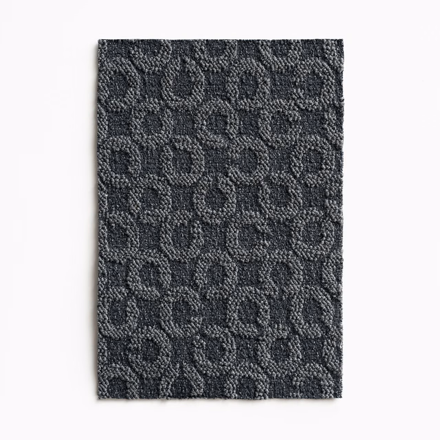 Dark blue-jeans textile swatch with raised charcoal loops in a compact woven pattern