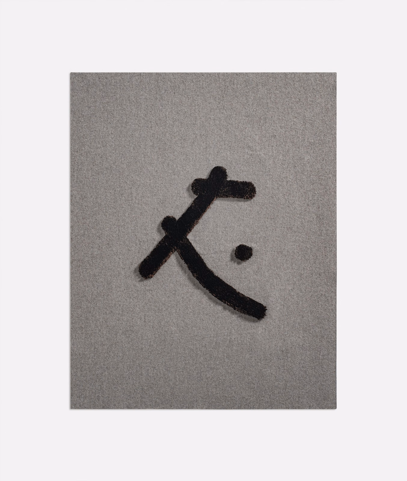 Taupe-grey woven fabric with a raised black abstract mark and separate dot
