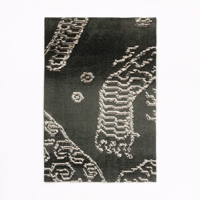 Charcoal woven fabric with pale petrified-wood lines and scattered stone-like medallions