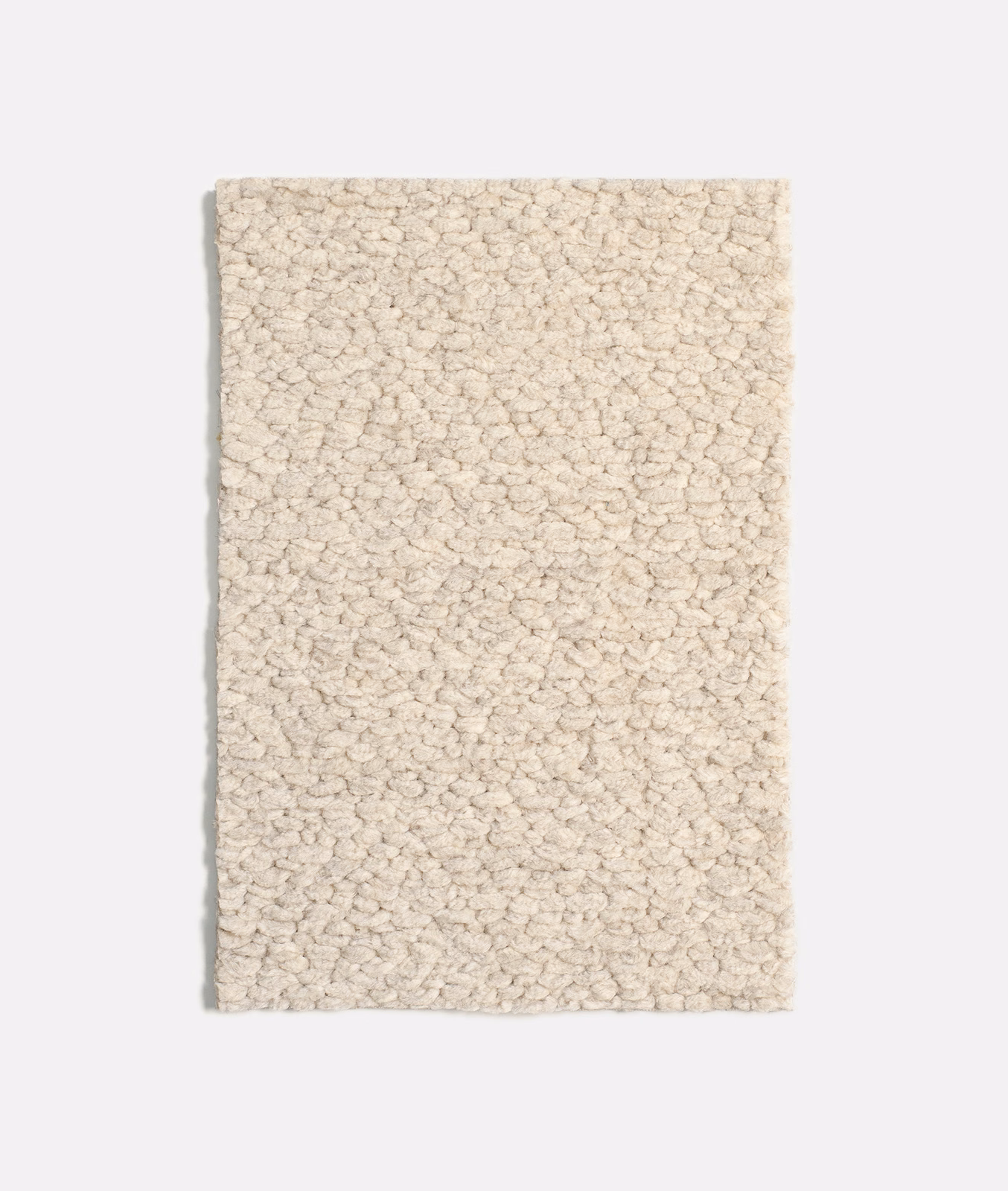 Pale cream bouclé upholstery swatch with dense irregular loops and softly flecked texture