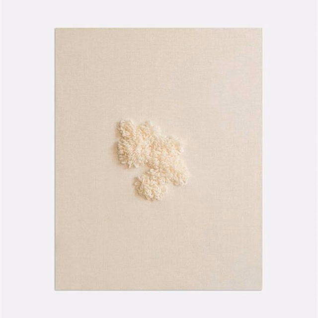 Pale ivory woven ground with a small raised warm-cream tufted motif