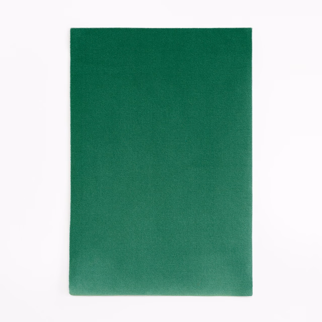 Saturated forest green velvet swatch with subtle tonal nap variation across its plain surface