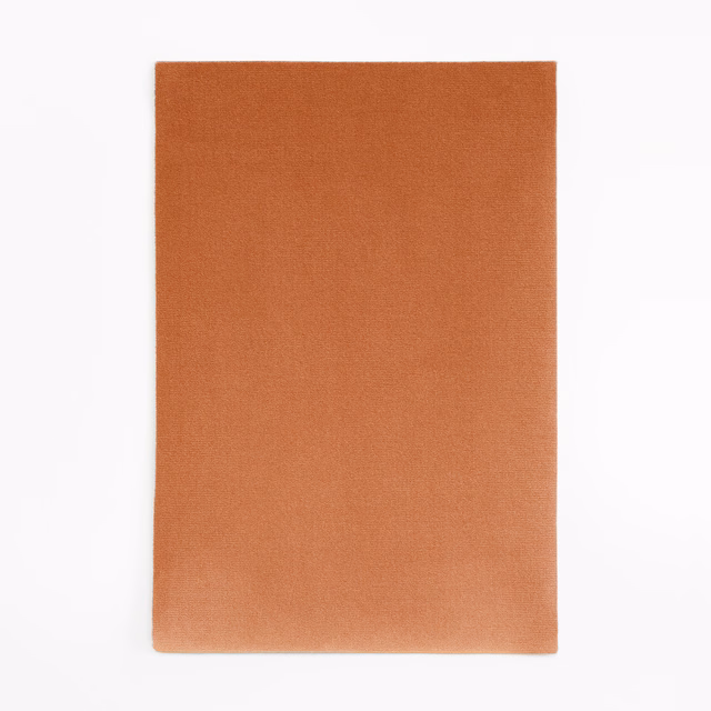 Warm saffron-orange velvet swatch with smooth plain pile and subtle tonal shading