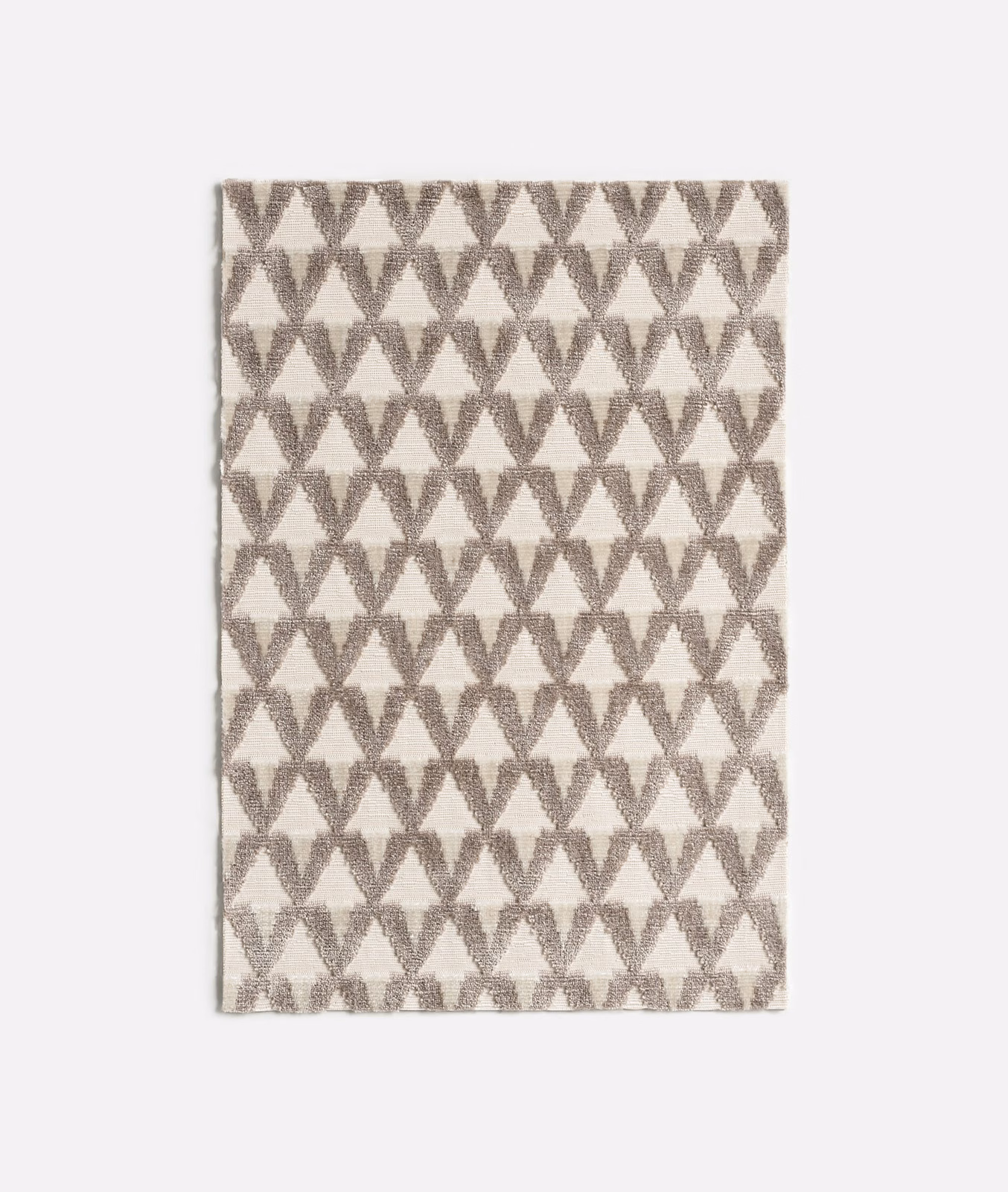 Alabaster velvet with repeating soft taupe hourglass motifs and subtle surface depth