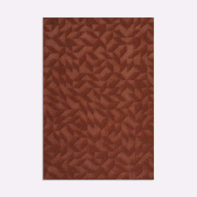 Warm russet terracotta velvet with raised angular leaf-like motifs and directional texture