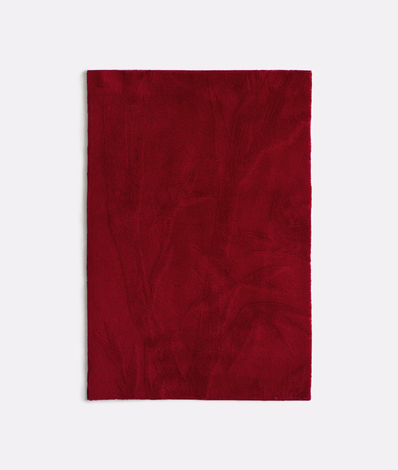 Deep burgundy velvet swatch with faint tonal botanical outlines and softly shifting pile