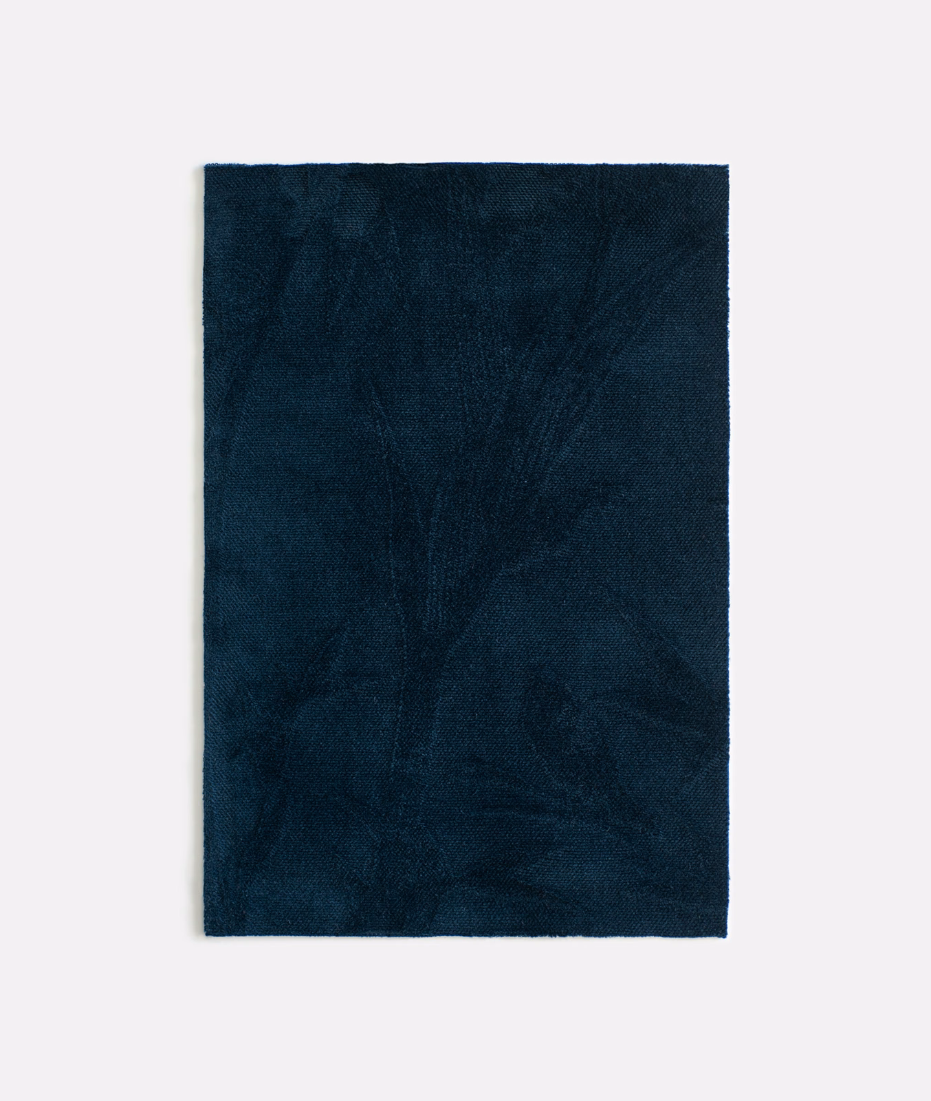 Deep ink-blue velvet swatch showing faint branching leaves across its surface