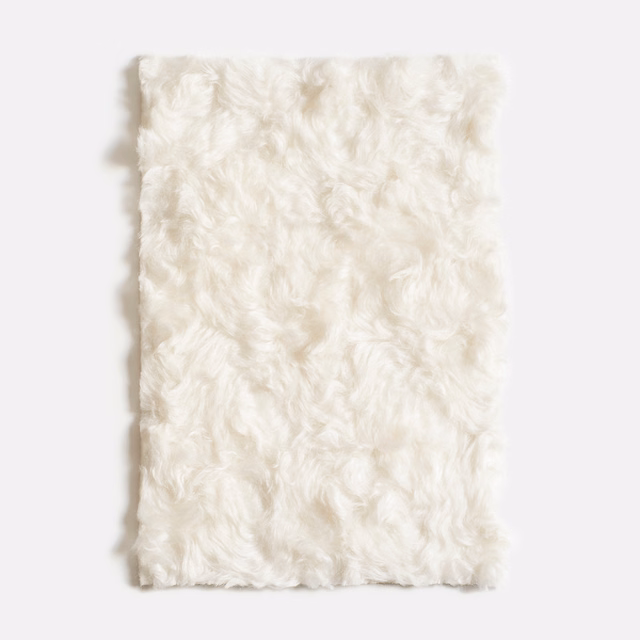 Warm ivory velvet swatch with plush curled pile and softly shadowed texture