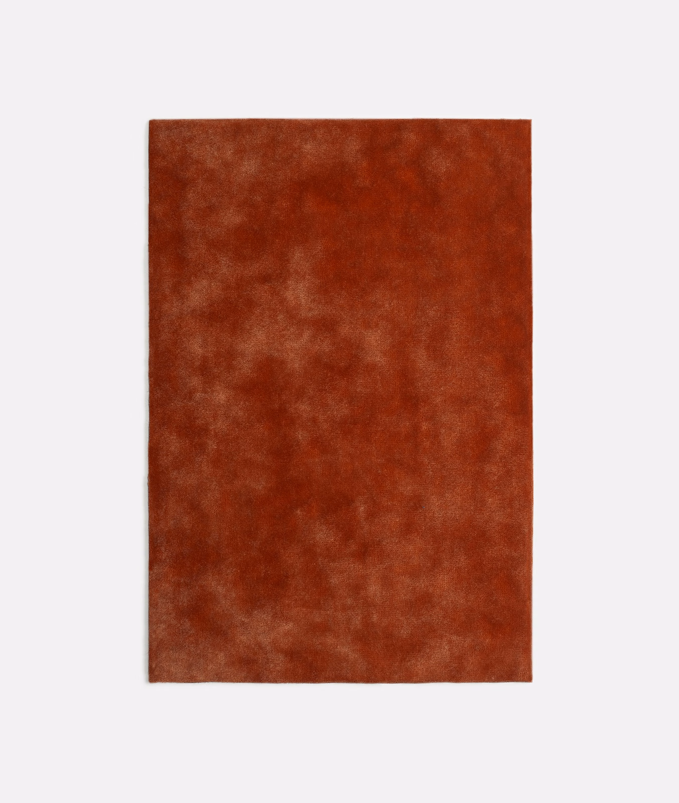 Mottled rust-red terracotta velvet with cloudy highlights across the pile
