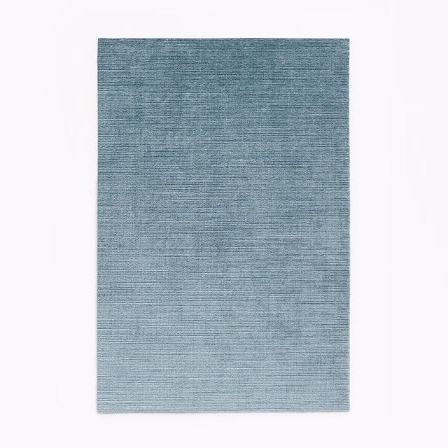 Muted blue-grey velvet swatch with fine horizontal striations and softly varied denim tones