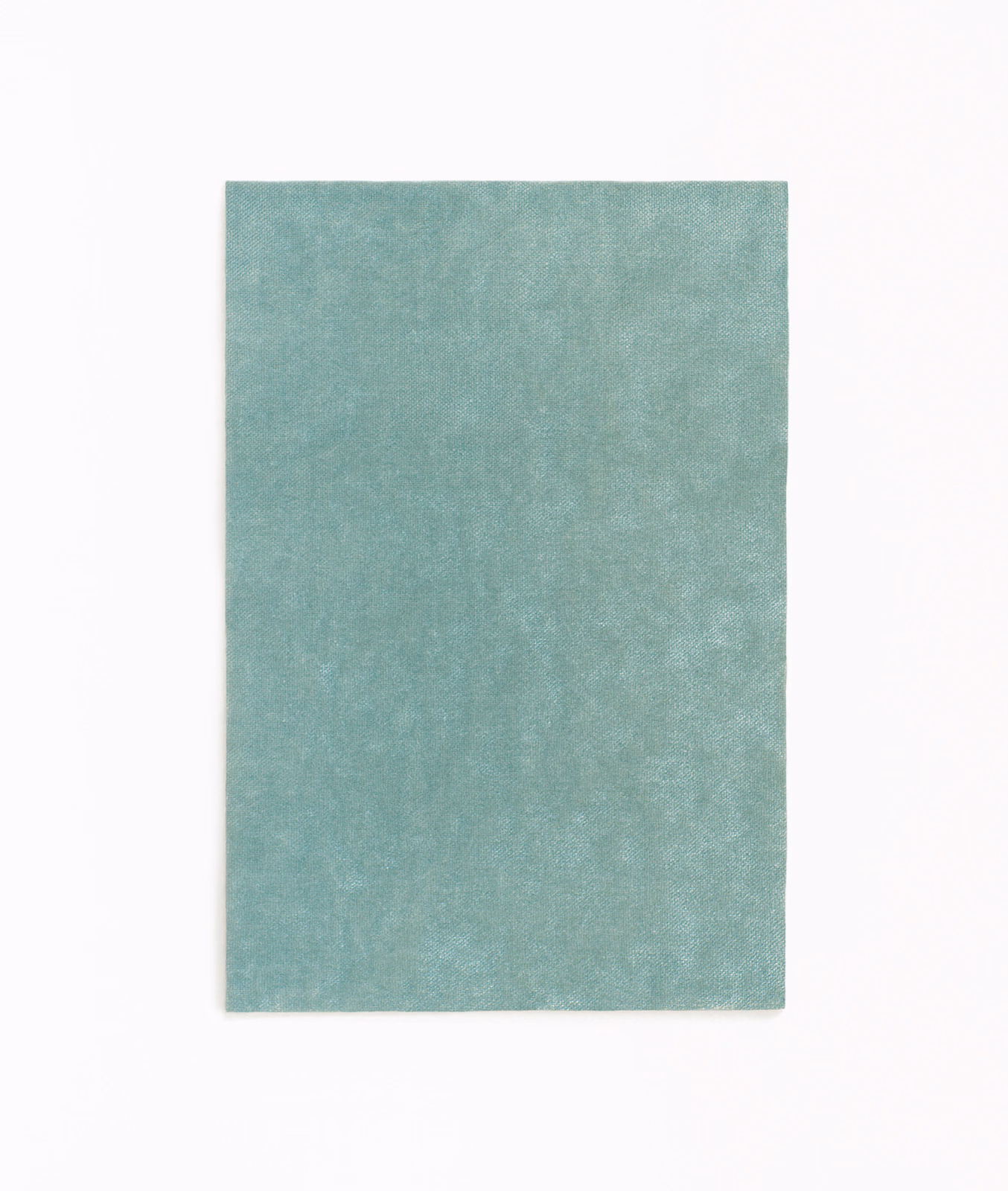 Close-up of softly mottled cool celadon green velvet with a gentle plush sheen