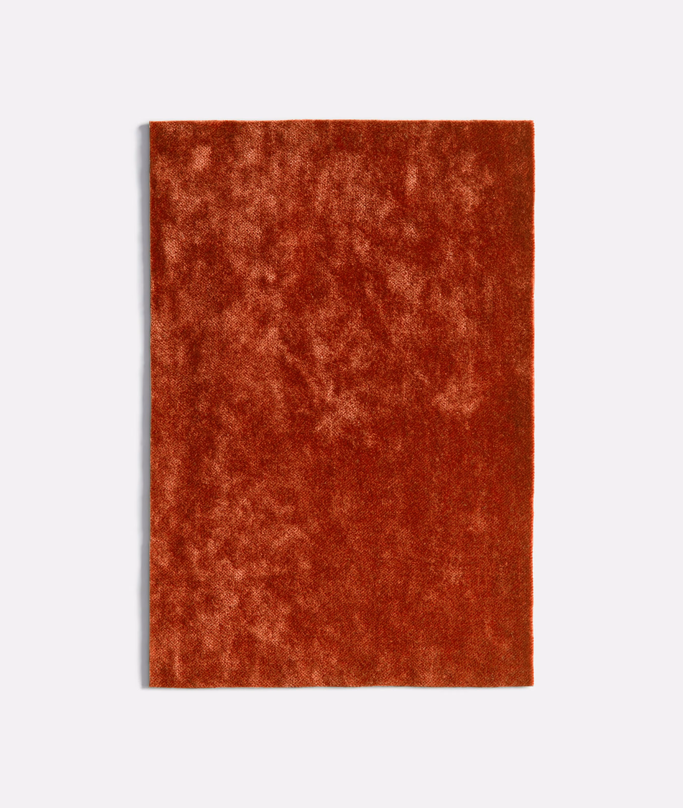 Burnt-coral velvet swatch with cloudy rust mottling and a plush light-catching pile