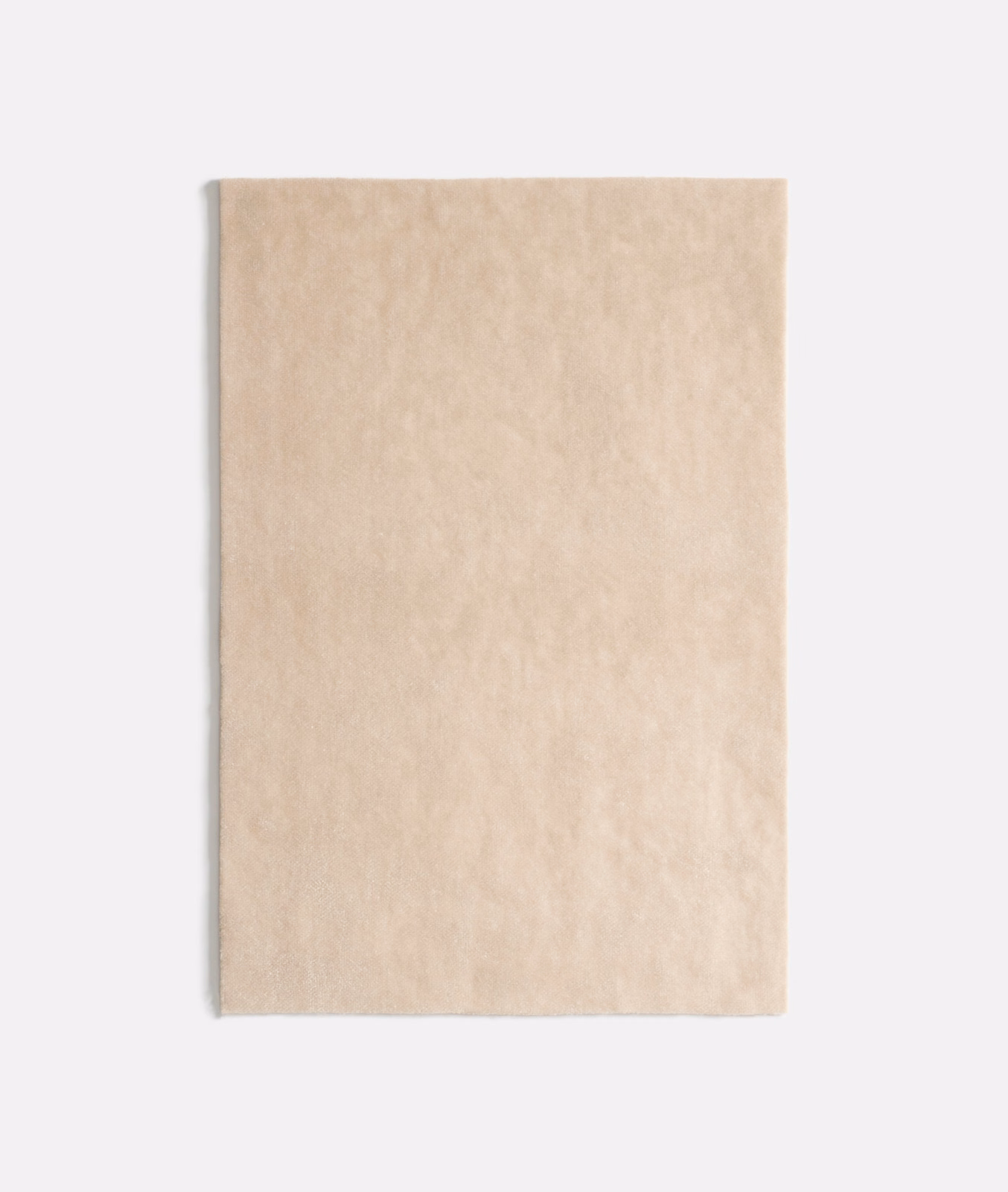 Pale warm beige velvet swatch with softly mottled plush nap and gentle light variation
