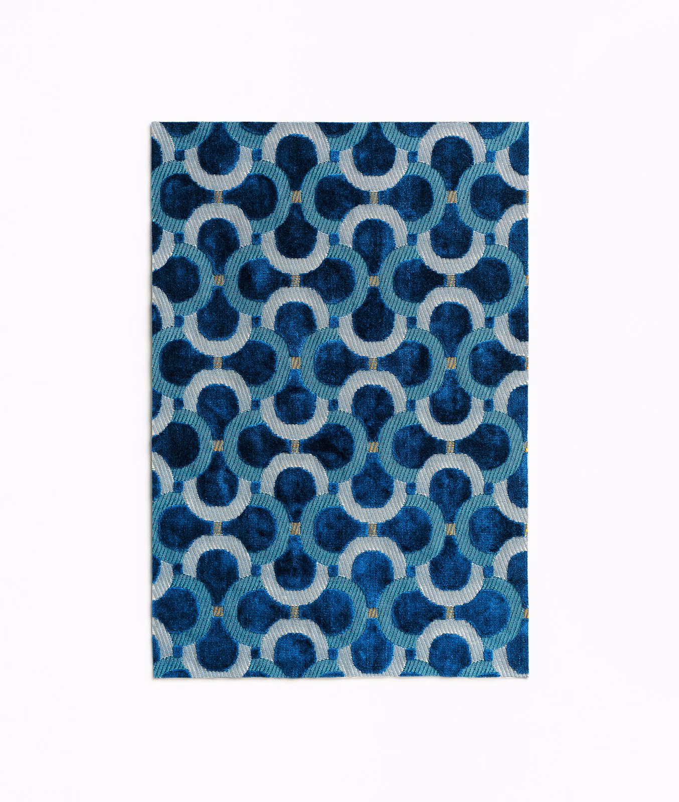 Prussian blue velvet with ivory interlocking loops, teal shading and tiny ochre accents