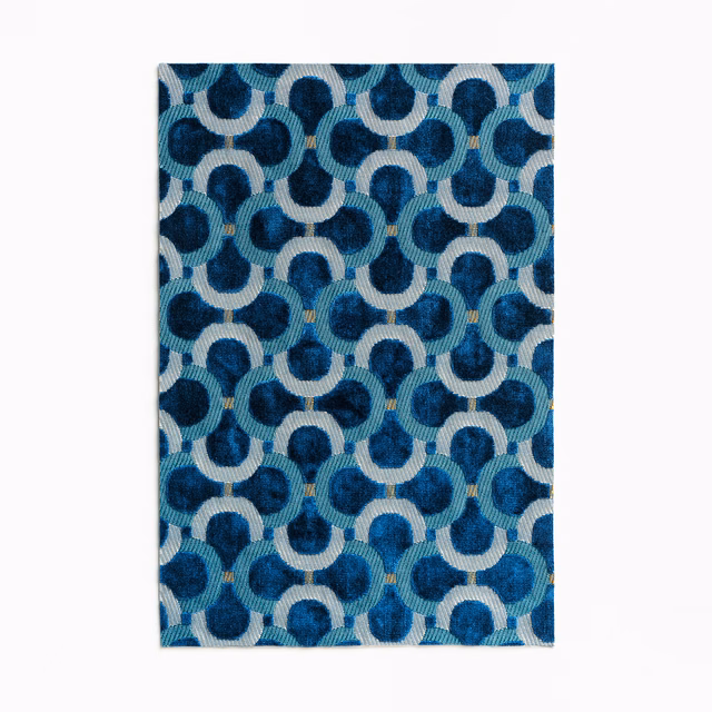 Prussian blue velvet with ivory interlocking loops, teal shading and tiny ochre accents