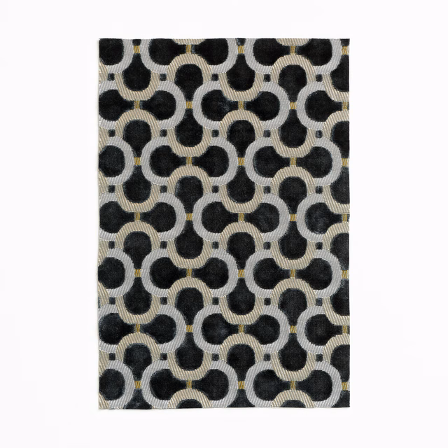 Charcoal velvet swatch with black rounded links, pale ground and tiny ochre accents