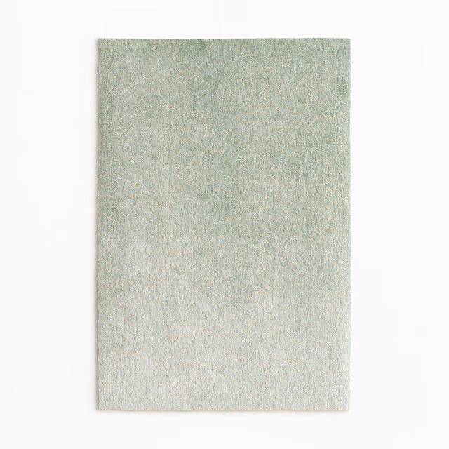 Pale sage green velvet swatch with fine mottled texture and subtle warm gold sheen